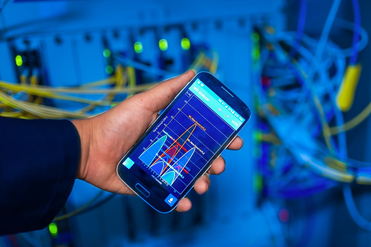The Art of Drawing Readers In: Your attractive post title goes here Hand holding smartphone displaying network analysis in high-tech server environment.
