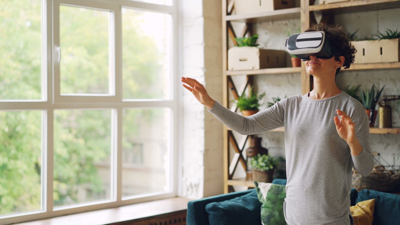 Crafting Captivating Headlines: Your awesome post title goes here An adult woman wearing VR goggles, interacting with virtual reality in a modern indoor setting.
